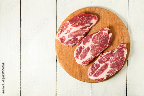 Sliced raw pork meat on wooden surface, top view