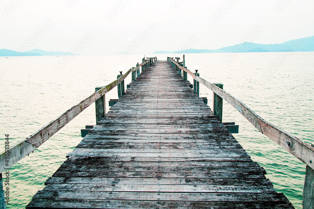 A wooden walkway that stretches into the sea. vacation travel concept. long wooden bridge in the sea