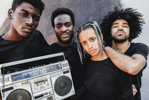 Fotobehang Group of young african people listening music from vintage boombox stereo outdoo