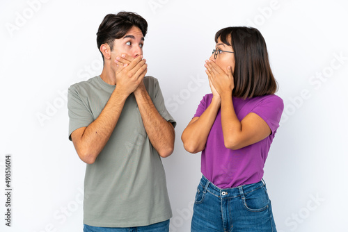 Young couple isolated on isolated white background covering mouth with hands for saying something inappropriate