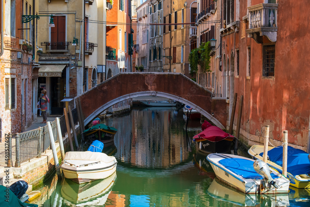 VENICE, ITALY - August 27, 2021: Beautiful view of Venice's canals with tourists strolling through its streets