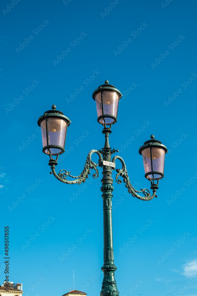 Typical Venetian lamppost with a blue background