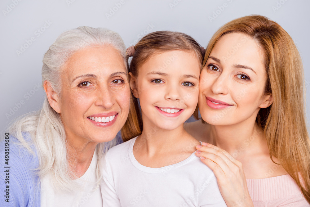 Portrait of three peaceful idyllic people cuddle beaming smile look camera isolated on grey color background Portrait of three peaceful idyllic people cuddle beaming smile look camera isolated on grey color background
