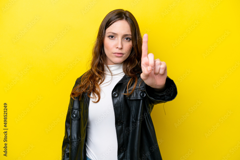 Young caucasian woman isolated on yellow background counting one with serious expression Young caucasian woman isolated on yellow background counting one with serious expression