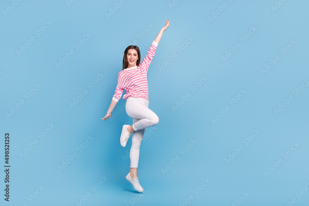 Full size photo of cheerful pretty person enjoy jumping have good mood isolated on blue color background Full size photo of cheerful pretty person enjoy jumping have good mood isolated on blue color background