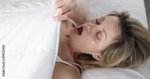 Woman wakes up and looks under covers in fear