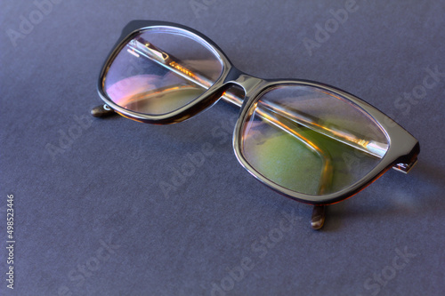 Anti-glare coating on the glasses. Glasses with black frames on a dark background. photo