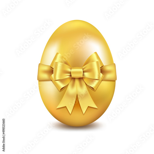 Golden shiny Easter egg with golden silk bow. Easter souvenir.