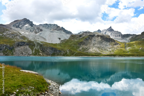 Fototapeta Naklejka Na Ścianę i Meble -  Savoie, France. Mountains and sky reflection in Alpine lake in Sassiere valley.