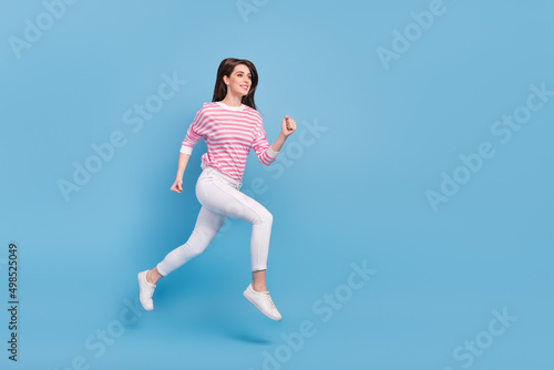 Fototapeta Naklejka Na Ścianę i Meble -  Full size profile portrait of energetic excited lady run look empty space isolated on blue color background