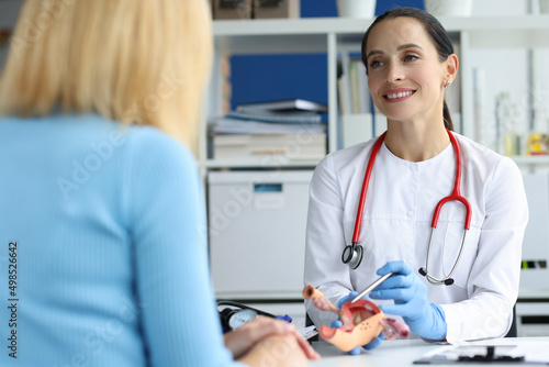 фотографія Gynecologist holds model of female reproductive system of uterus and consults pa