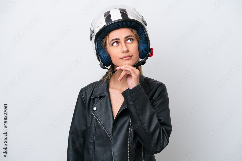 Young caucasian woman with a motorcycle helmet isolated on white background and looking up Young caucasian woman with a motorcycle helmet isolated on white background and looking up