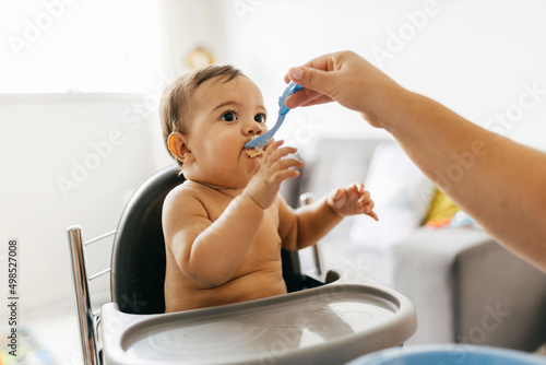 Mother feeding child. First solid food for children. Baby weaning