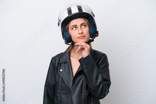Young caucasian woman with a motorcycle helmet isolated on white background and looking up © luismolinero