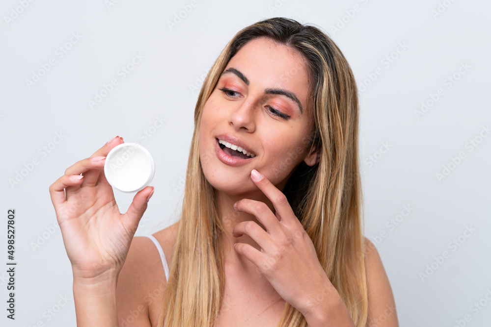 Young caucasian woman isolated on white background with moisturizer Young caucasian woman isolated on white background with moisturizer