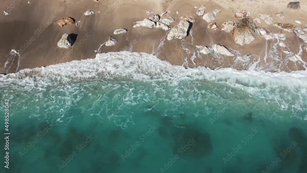 4K aerial shot from a drone from above, the purest turquoise waters break on the rocks near the shore and foam. Surf splashes are scattered in slow motion 4K aerial shot from a drone from above, the purest turquoise waters break on the rocks near the shore and foam. Surf splashes are scattered in slow motion