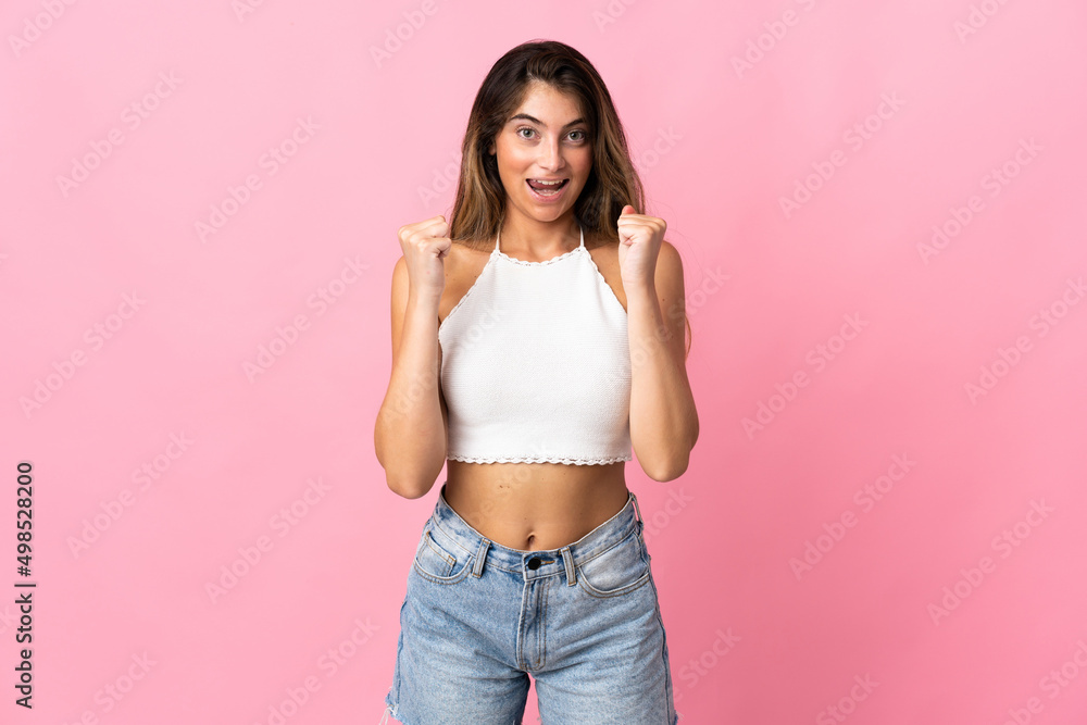 Young caucasian woman isolated on pink background celebrating a victory in winner position Young caucasian woman isolated on pink background celebrating a victory in winner position