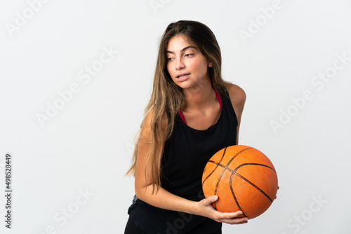 Young caucasian woman isolated on white background playing basketball © luismolinero