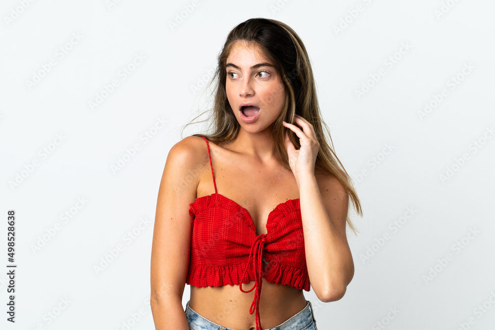 Fototapeta premium Young caucasian woman isolated on white background doing surprise gesture while looking to the side