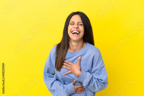 Young caucasian woman isolated on yellow background smiling a lot © luismolinero