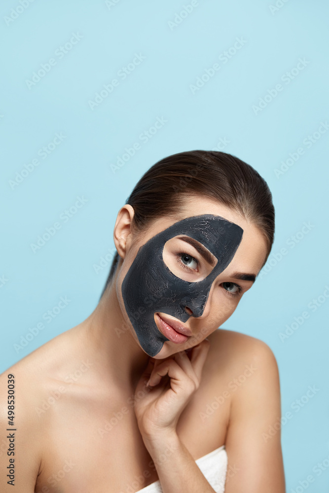 Beauty Woman Face Skin Care Mask. Portrait of a Beautiful Female with a Black Mask of Clay on Face . Spa treatment . Girl Model with Moisturizer Cosmetic Mask Touches her Face. Beauty Woman Face Skin Care Mask. Portrait of a Beautiful Female with a Black Mask of Clay on Face . Spa treatment . Girl Model with Moisturizer Cosmetic Mask Touches her Face.
