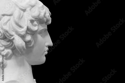 white plaster male statue isolated on black background