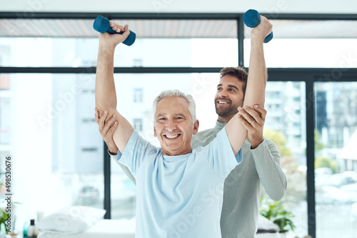 Physiotherapy works. Shot of a friendly physiotherapist helping his senior patient work out with weights.