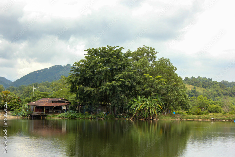 Scenic view of a riverside village with lush green surroundings in the outskirts of the town of Ipoh in Malaysia.