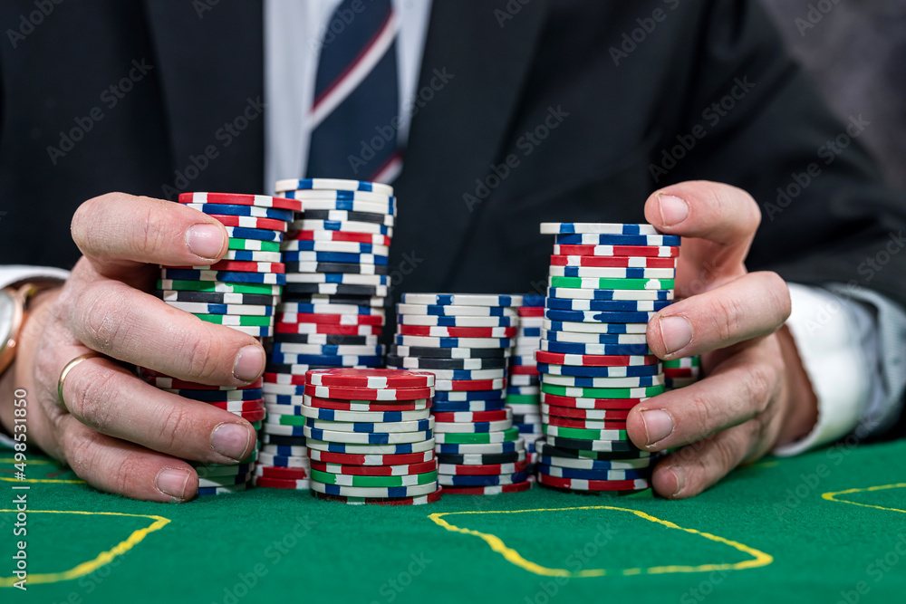 Naklejka premium Poker player in suit holding casino chips