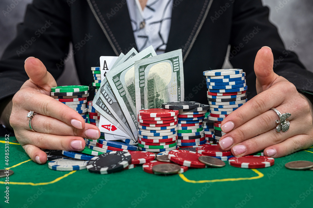 female player counts chips on money and raises bet by playing poker at casino female player counts chips on money and raises bet by playing poker at casino