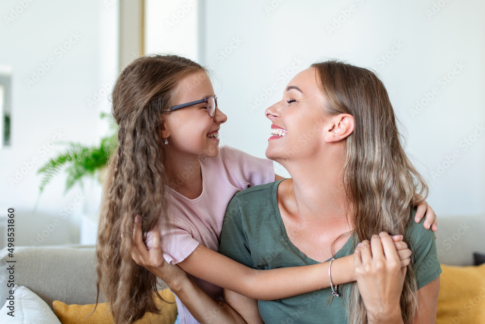 Loving young mother laughing embracing smiling cute funny kid daughter enjoying time together at home, happy family single mom with little child girl having fun playing feel joy cuddling and hugging Loving young mother laughing embracing smiling cute funny kid daughter enjoying time together at home, happy family single mom with little child girl having fun playing feel joy cuddling and hugging