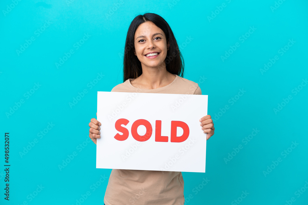 Young woman over isolated background holding a placard with text SOLD with happy expression Young woman over isolated background holding a placard with text SOLD with happy expression