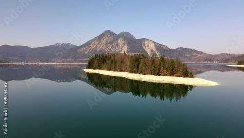 Aerial drone of Island of Sassau in Lake Walchen, Walchensee in Bavaria Germany, with Herzogstand mountain in spring in 4k, HD und UHD