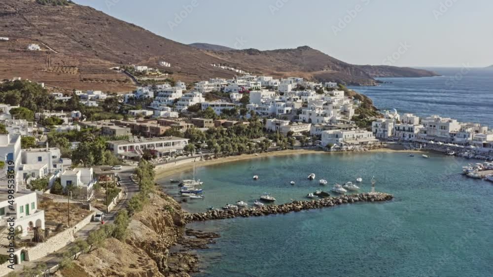 Piso Livadi Paros Greece Aerial v2 low level fly around stunning small harbor, hillside village town, panning reveals beautiful aegean seascape with endless horizon - September 2021 Piso Livadi Paros Greece Aerial v2 low level fly around stunning small harbor, hillside village town, panning reveals beautiful aegean seascape with endless horizon - September 2021