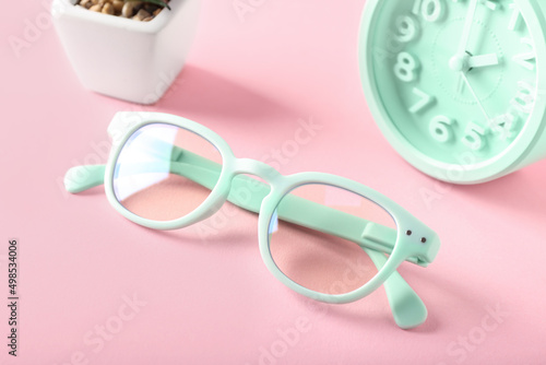 Stylish eyeglasses on pink background, closeup