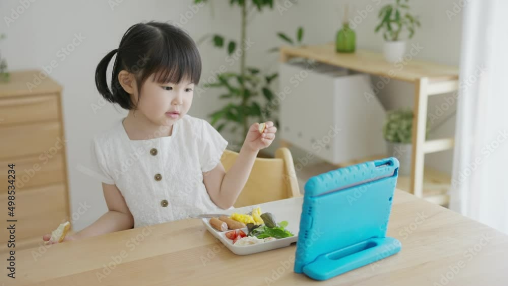 タブレットを見ながら食事をする子供(育児・子育て) タブレットを見ながら食事をする子供(育児・子育て)