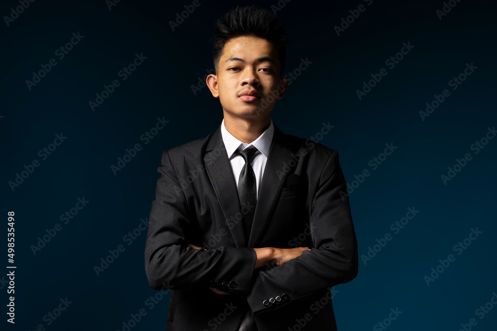 Handsome young man in suit facing dark themed camera Handsome young man in suit facing dark themed camera