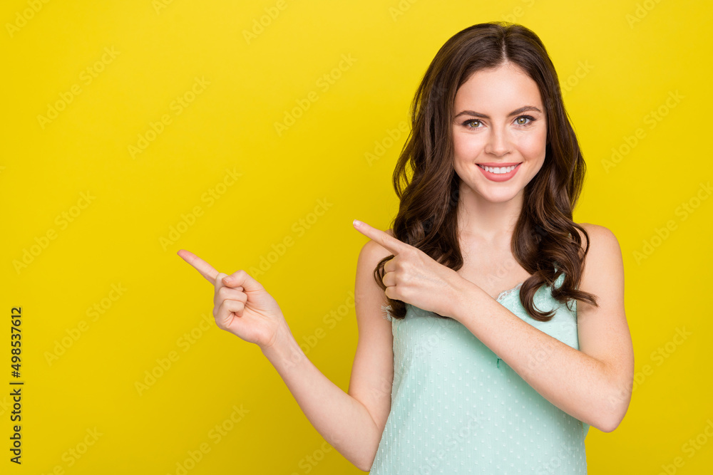 Photo of adorable positive female recommend promote offer product isolated on yellow color background Photo of adorable positive female recommend promote offer product isolated on yellow color background