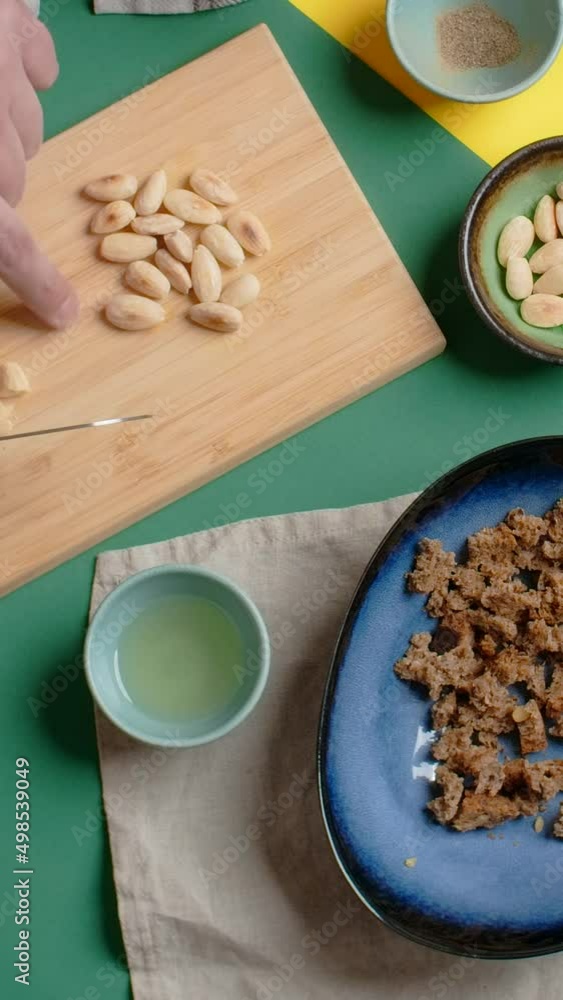 Vertical flat lay video: chef cookes meal with cutted almonds Vertical flat lay video: chef cookes meal with cutted almonds