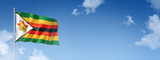 Zimbabwe flag isolated on a blue sky. Horizontal banner