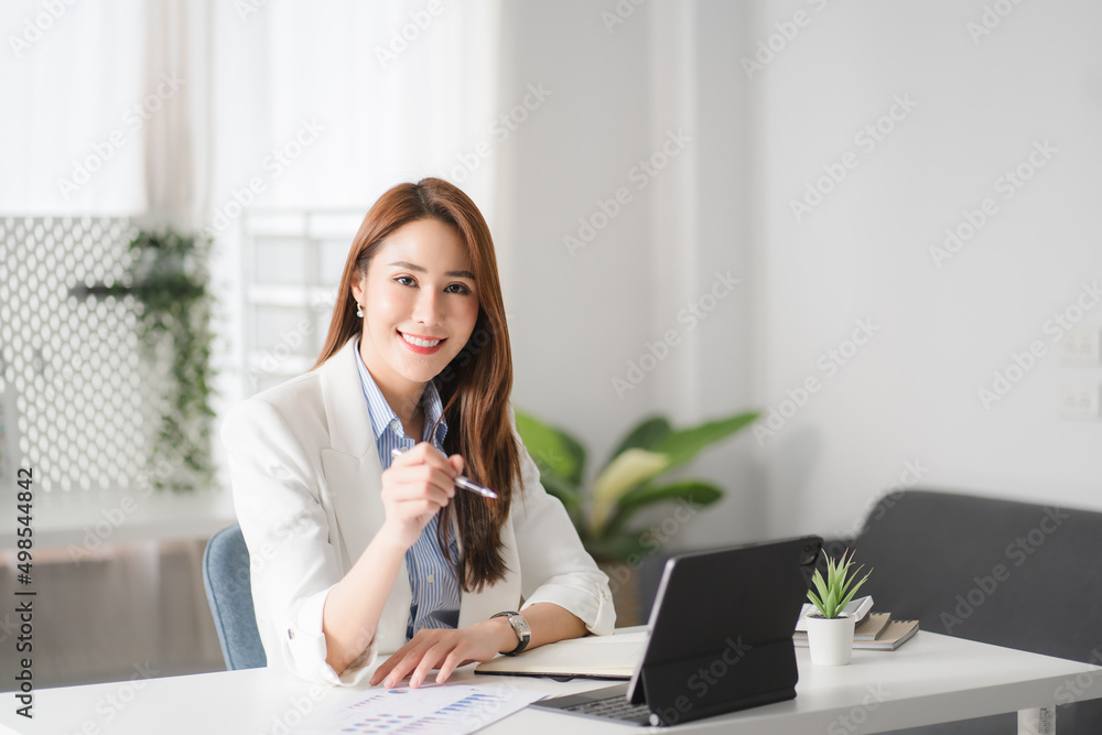 Portraits of beautiful smiling Asian women relax using laptop computer technology while sitting on their desks and using their creativity to work, work from home concept. Portraits of beautiful smiling Asian women relax using laptop computer technology while sitting on their desks and using their creativity to work, work from home concept.