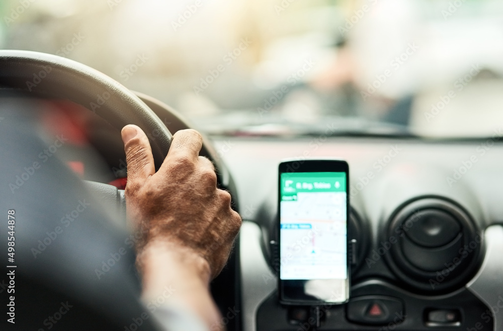 Youll never be lost with modern technology. Closeup shot of a man using a phone to find directions while driving.