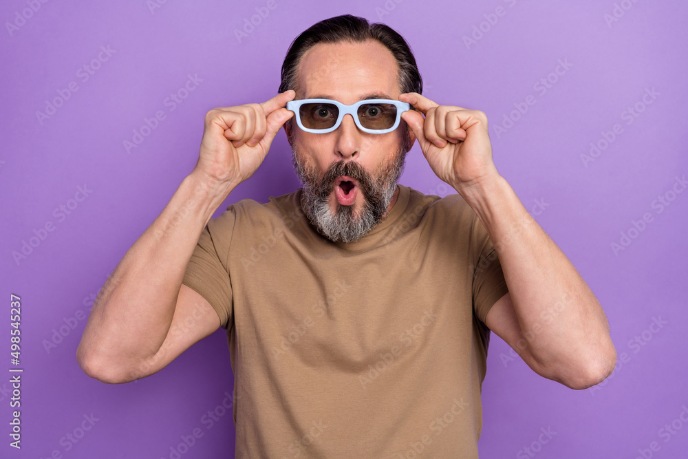 Portrait of mature impressed man with open mouth watch interesting detective 3d movie isolated on purple color background Portrait of mature impressed man with open mouth watch interesting detective 3d movie isolated on purple color background