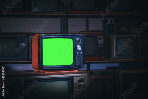 Retro old television with green screen in the old storage room. Vintage old tv technology.