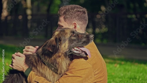 Man hugging and petting german shepherd dog, friendship between dog and human photo