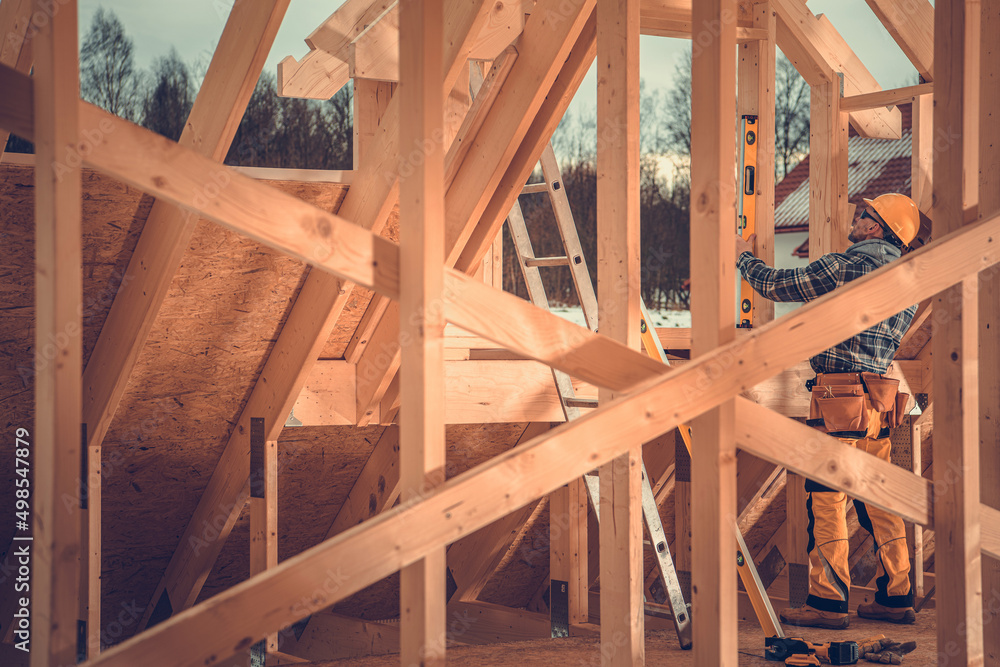 Construction Contractor Supervisor Performing Final Levels Check on Wooden Skeleton Frame Construction Contractor Supervisor Performing Final Levels Check on Wooden Skeleton Frame