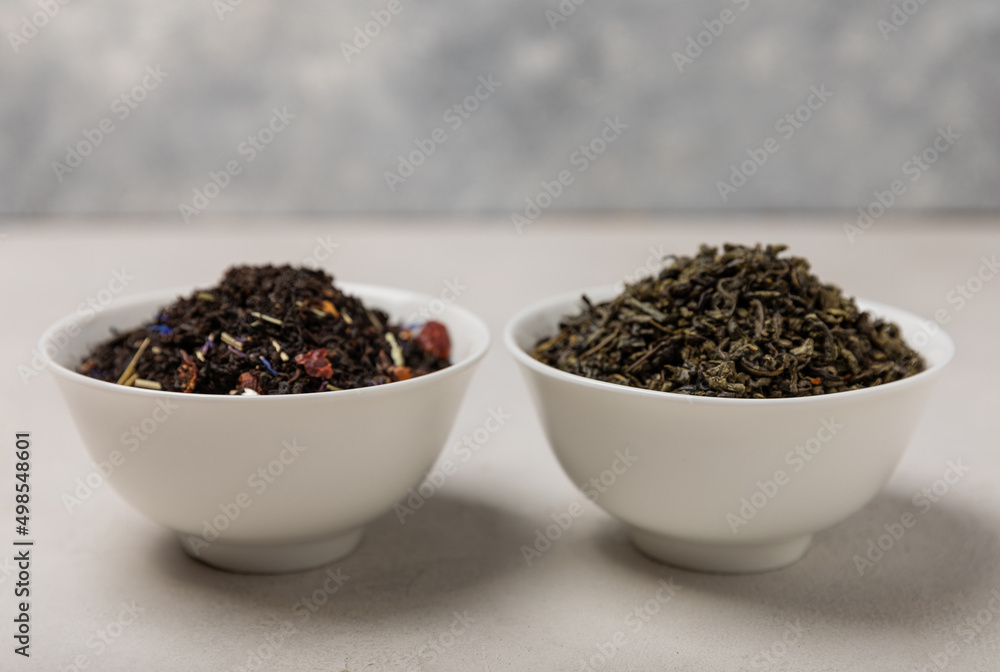 Black and green tea in ceramic bowls on a light background. View from above. Tea ceremony. Tonic drink. Black and green tea in ceramic bowls on a light background. View from above. Tea ceremony. Tonic drink.