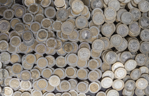 Pile of Colombian coins of 500 and 1000 denominations over wooden background. Ideal for economy  money  banks  save money and finance. 