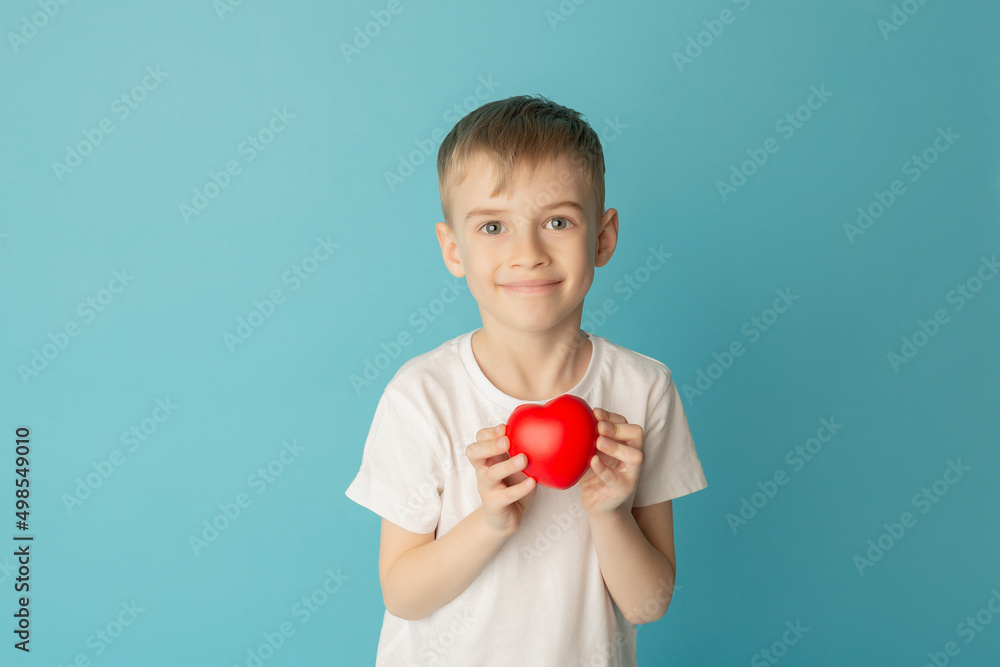 Children holding the red heart on a blue background. Concept of love, care, faith, hope, purity. Place for text. Flat fly Children holding the red heart on a blue background. Concept of love, care, faith, hope, purity. Place for text. Flat fly