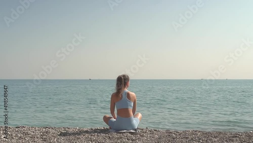 Girl Looks At The Sea Sitting On The Beach.